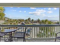 Relaxing balcony view with seating overlooking tropical landscaping and parking at 1300 Ocean Blvd # 238, Isle of Palms, SC 29451