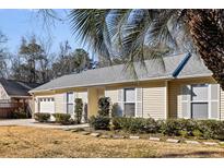 Charming one-story home with a manicured lawn, complemented by lush greenery and a serene suburban setting at 1701 Sailfish Dr, Johns Island, SC 29455