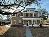 Two-story home with gray siding, white trim, dormer, covered front porch, and professional landscaping at 343 Wappoo Rd, Charleston, SC 29407