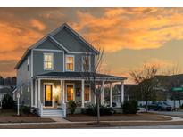 Charming two-story home with covered front porch, manicured lawn and beautifully landscaped yard at sunset at 3529 Sewel Ave, Mount Pleasant, SC 29466