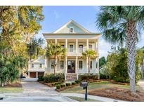 Stunning two-story home featuring double porches, lush landscaping, and a detached two-car garage at 388 Evian Way, Mount Pleasant, SC 29464
