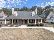 Charming single-story brick home featuring a welcoming front porch with classic white columns and manicured landscaping at 4869 Habersham Ln, Summerville, SC 29485