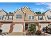 Charming two-story townhome with a one car garage, manicured landscaping, and a welcoming entrance at 804 Buckthorn Cir, Summerville, SC 29483