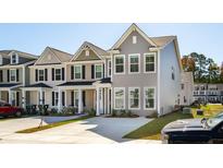 A row of charming two-story townhomes with landscaped yards and concrete driveways at 808 Alma Square Dr, Moncks Corner, SC 29461