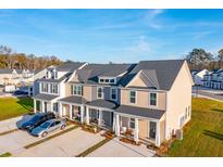 New townhomes featuring well-manicured lawns, inviting front porches, and convenient parking spaces at 812 Alma Square Dr, Moncks Corner, SC 29461