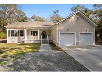 Charming home features a covered front porch and a convenient two-car attached garage at 8255 Chisolm Plantation Rd, Edisto Island, SC 29438