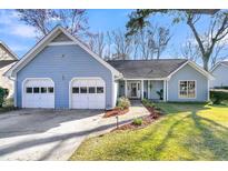 Charming single-story home with a well-manicured lawn, two car garage and inviting brick walkway at 8405 Polo Pt, Charleston, SC 29418