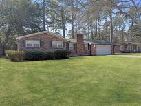 Charming brick ranch home featuring a spacious front lawn and attached garage at 108 Harter Dr, Summerville, SC 29485