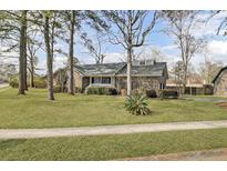 Charming brick home with a well-manicured front lawn and mature trees in a serene setting at 1205 Scotch Pine Ln, Ladson, SC 29456