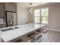 Bright kitchen features stainless steel appliances, gray cabinetry, white countertops, and a breakfast bar with seating at 130 River Landing Drive # 8209, Charleston, SC 29492