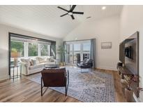 Bright living room featuring vaulted ceilings, wood floors, a large window, and sliding doors to the outside at 1338 Pelican Watch Villas, Seabrook Island, SC 29455