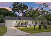 Charming, single-story home features a brick facade, dark roof, palm trees, and well-maintained lawn at 1520 Wakendaw Rd, Mount Pleasant, SC 29464