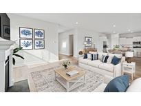 Bright living room with white sofa, blue pillows, light wood floors, fireplace, and decor at 231 Denham St, Summerville, SC 29486