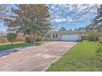 Charming brick home features an attached garage, a spacious driveway, and a well-maintained front lawn at 2529 Otranto Rd, North Charleston, SC 29406