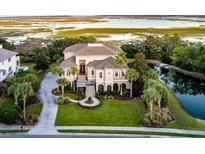 Stunning waterfront home boasts lush landscaping, grand entrance, and elegant architectural details at 4935 Sound View Dr, Mount Pleasant, SC 29466