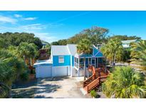 Beautiful blue home with a metal roof, garage, wooden stairs, and a screened-in porch at 5 25Th Ave, Isle of Palms, SC 29451