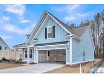 Beautiful, light blue home features an attached two-car garage, a covered porch, and a gabled roof at 429 Grove End Rd, Moncks Corner, SC 29461