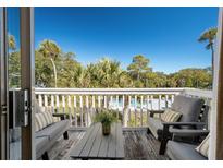 Relax on this charming balcony, offering serene views of the community pool and tropical landscape at 8 Lagoon Villas, Isle of Palms, SC 29451