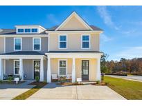 Charming two-story townhome featuring a welcoming front porch with a neutral-tone exterior and well-manicured landscaping at 816 Alma Square Dr, Moncks Corner, SC 29461