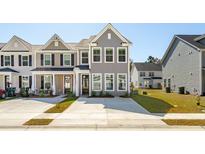 Charming townhome with manicured lawn and welcoming curb appeal on a sunny day at 818 Alma Square Dr, Moncks Corner, SC 29461