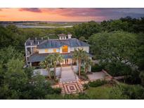 Stunning two-story home featuring palm trees, manicured landscaping, a rooftop terrace and views of the marsh at 1105 Fort Lamar Rd, James Island, SC 29412