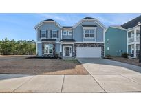 Charming two-story home with a two-car garage, stone accents, and blue siding at 115 Headwater Dr, Summerville, SC 29486
