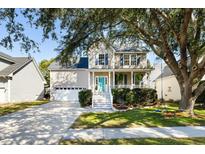 Charming two-story home featuring a quaint front porch, manicured lawn, and a welcoming turquoise-painted front door at 1242 Caperton Way, Charleston, SC 29412