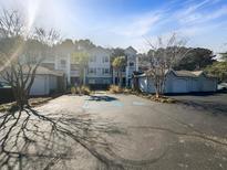 View of the apartment building exterior, showcasing ample parking, landscaping, and accessible parking spaces at 1300 Park West Blvd # 420, Mount Pleasant, SC 29466
