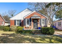 Charming brick home featuring black shutters, manicured landscaping, and a cozy front porch at 18 Sothel Ave, Charleston, SC 29407
