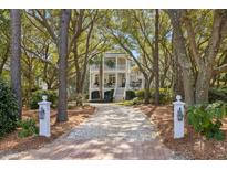 Charming two-story home with a long drive, lush trees, and a welcoming entrance at 2863 Jasper Blvd, Sullivans Island, SC 29482