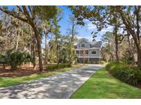 Stately two-story home with gray siding, covered porch, and lush landscaping at 2928 Baywood Dr, Seabrook Island, SC 29455