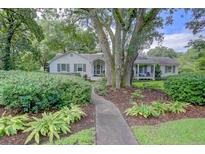 Charming single-story home with mature trees, lush landscaping and welcoming front porch at 299 Hobcaw Dr, Mount Pleasant, SC 29464