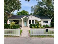 Charming home with a neatly landscaped yard, white picket fence and a welcoming front porch at 313 Queen St, Mount Pleasant, SC 29464