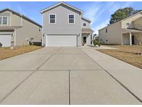 Charming two-story home features a light gray facade, white trim, and a spacious concrete driveway at 344 Iveson Rd, Summerville, SC 29486