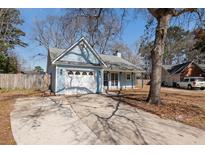 Charming light blue home featuring an attached garage and spacious driveway at 4788 Porter Dr, North Charleston, SC 29420