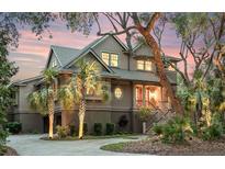 Stately home featuring lush landscaping, a circular driveway, and a welcoming entrance at 57 Goldenrod Ct, Kiawah Island, SC 29455