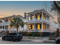 Charming two-story home featuring double porches, black shutters and a well-manicured front yard at 71 Moultrie St, Charleston, SC 29403