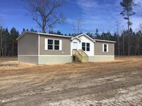Charming single-story home features neutral siding and a welcoming front entrance with wooden steps at 8833 Cottageville Hwy, Cottageville, SC 29435