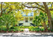 Charming two-story home with a welcoming front porch, lush landscaping, and mature trees providing ample shade at 935 Royall Ave, Mount Pleasant, SC 29464