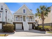 Charming two-story beach home with elevated entry, garage parking, and lush landscaping at 1025 Hunley Waters Cir, North Charleston, SC 29405