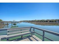 Picturesque waterfront view from a wooden dock with bench seating overlooking the tranquil waterway and distant trees at 1118 John Mcenery Rd, Charleston, SC 29412