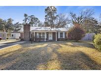 Charming brick home featuring a lovely metal roof and beautifully maintained front yard at 112 Robin Ct, Summerville, SC 29485