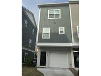 Modern townhome featuring a brick-base facade with a one car garage and a light-gray vertically paneled exterior at 1252 Allusion Ln # 201, Mount Pleasant, SC 29466