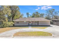 Charming single-story home featuring a circular driveway, manicured lawn, and mature trees at 1288 Old Colony Rd, Mount Pleasant, SC 29464