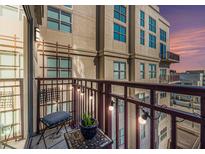 Cozy balcony featuring string lights, outdoor seating, and city views during a colorful sunset at 150 Bee St # 714, Charleston, SC 29401