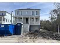 Two-story gray home featuring a white porch, garage, and manicured landscaping at 3107 S Shore Dr, Charleston, SC 29407