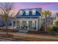 Charming home with inviting front porch, dormer windows and lush landscaping at 411 Watergrass Way, Summerville, SC 29485