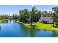Beautiful home featuring a lake and lush landscaping, creating a serene and picturesque setting at 4162 Ten Shillings Way, Hollywood, SC 29470