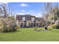 Charming brick home with a large front yard, dormer windows, and inviting front porch at 522 W Butternut Rd, Summerville, SC 29483