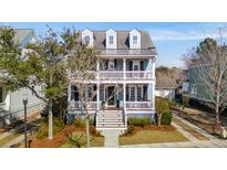 Charming two-story home featuring a welcoming double porch, dormer windows, and a well-manicured lawn at 8041 Gibbon St, Charleston, SC 29492